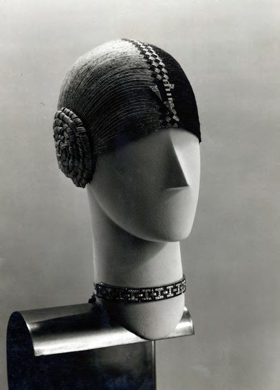 A  photograph  by  Thérèse  Bonney  of  the  Sandoz  boutique,  circa  1927, showing  a  smaller  triangular  brooch  affixed  to  a  hat  by  Germaine  Page.