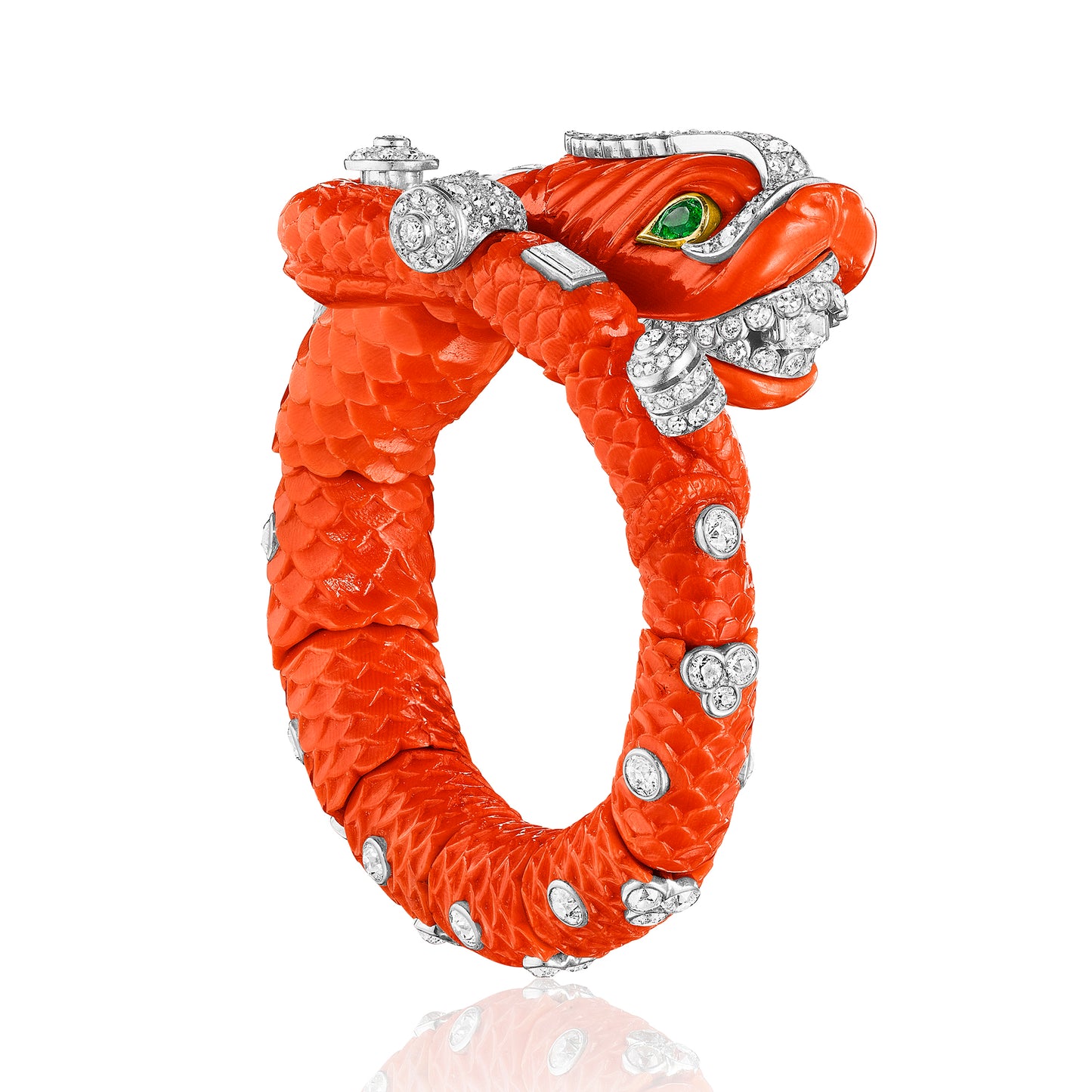 CARVED CORAL, EMERALD, AND DIAMOND CHIMERA BANGLE BY CARTIER, PARIS, CIRCA 1960