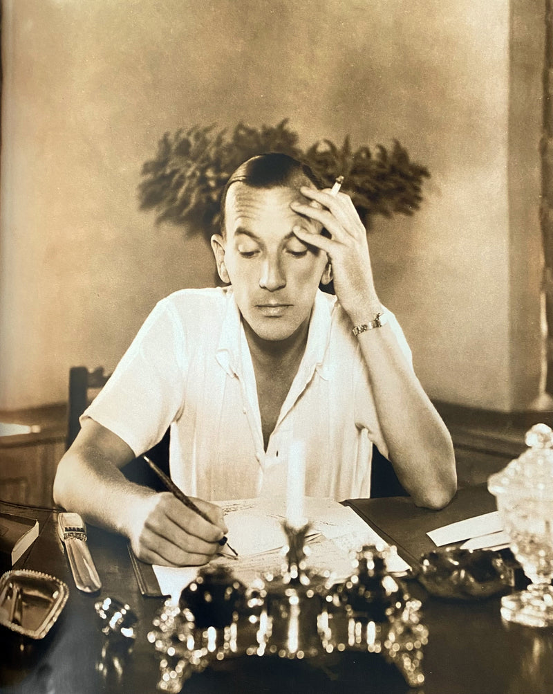 Playwright Noël Coward at his desk in 1935 with a Cartier agate paperknife timepiece at his side.