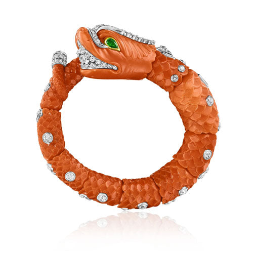 CARVED CORAL, EMERALD, AND DIAMOND CHIMERA BANGLE BY CARTIER, PARIS, CIRCA 1960